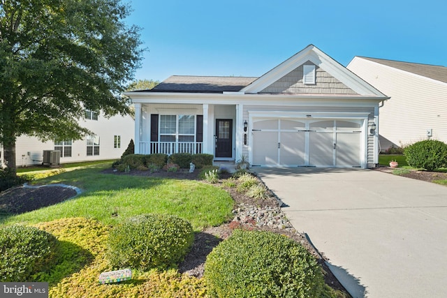 view of front facade featuring a front yard, cooling unit, and a garage