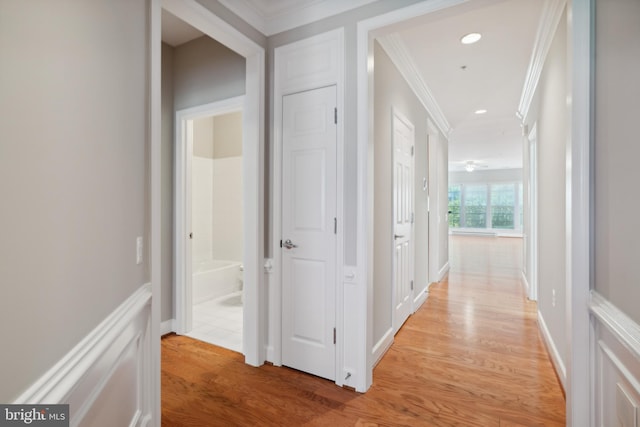 corridor featuring light hardwood / wood-style flooring and ornamental molding