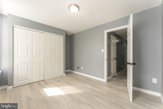 unfurnished bedroom with a closet and light hardwood / wood-style flooring