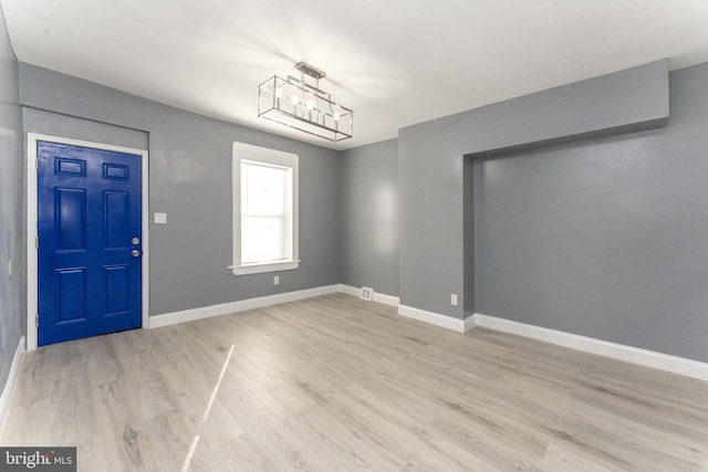 interior space with light hardwood / wood-style floors and an inviting chandelier