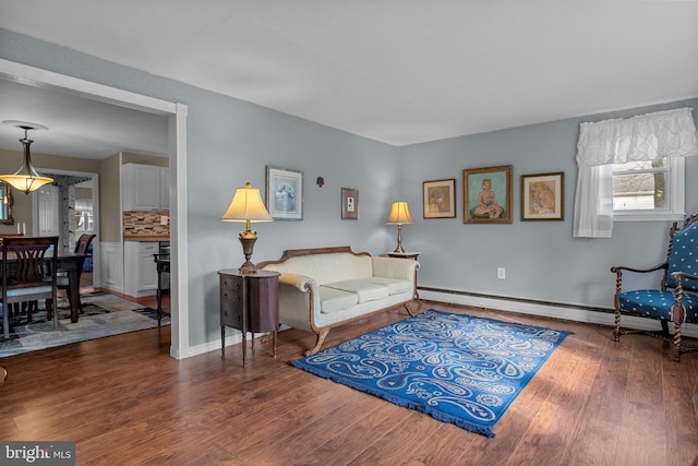 living room with dark wood-type flooring and a baseboard heating unit