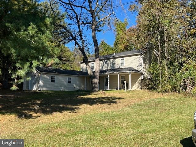 rear view of property featuring a lawn