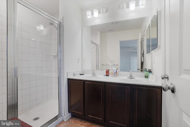 bathroom featuring a shower with door, vanity, and tile patterned floors