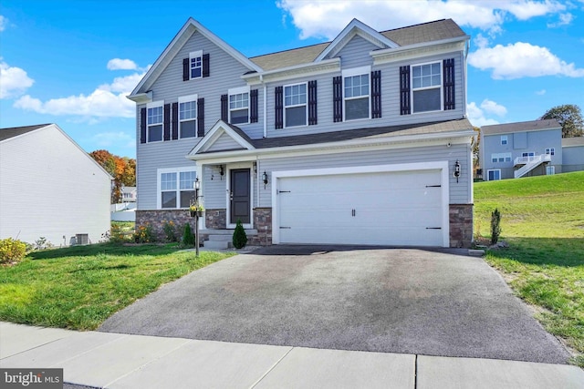 view of front of house featuring cooling unit, a front yard, and a garage