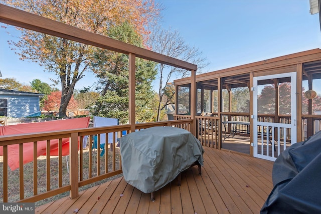 deck with a sunroom and a grill