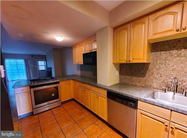 kitchen featuring decorative backsplash, appliances with stainless steel finishes, light brown cabinetry, light tile patterned flooring, and sink