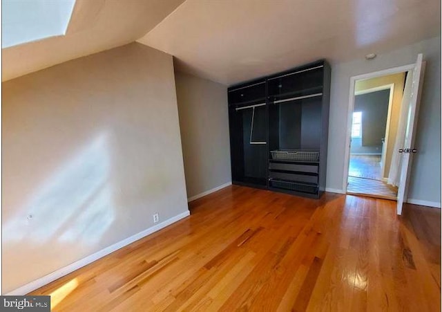 unfurnished bedroom with a closet, hardwood / wood-style floors, and a skylight