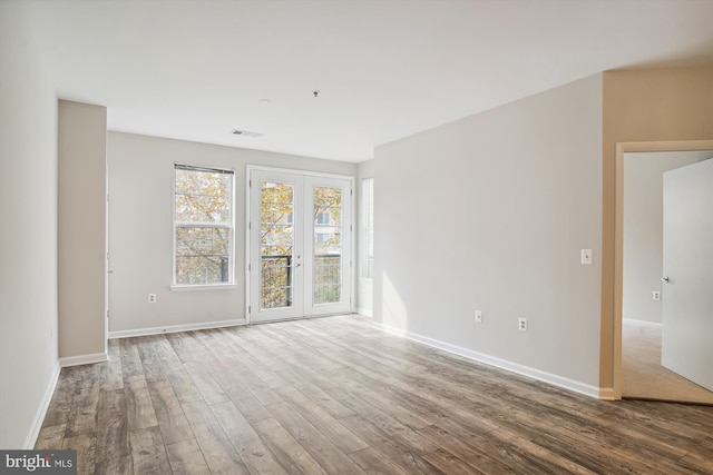 empty room with hardwood / wood-style floors and french doors