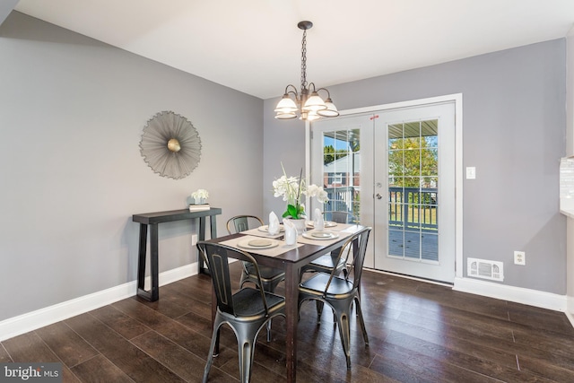 dining space with a chandelier, dark wood-type flooring, and french doors