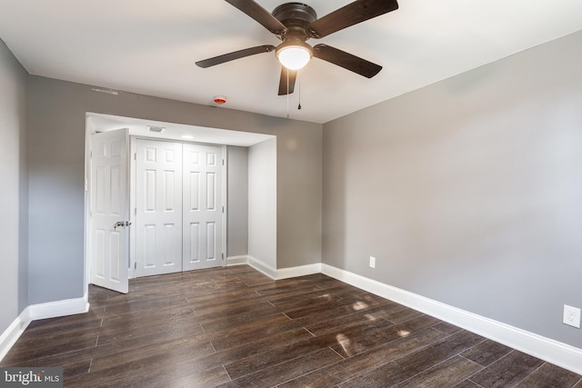 unfurnished bedroom featuring dark wood-type flooring, ceiling fan, and a closet