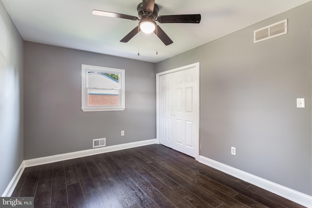 unfurnished bedroom with dark hardwood / wood-style floors, a closet, and ceiling fan