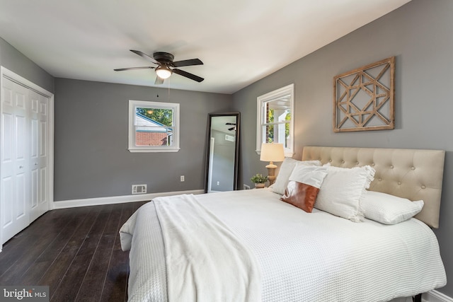 bedroom with a closet, dark hardwood / wood-style floors, and ceiling fan