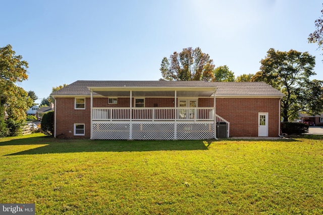 back of property with a yard and a deck