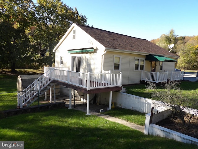 back of house featuring a deck and a lawn