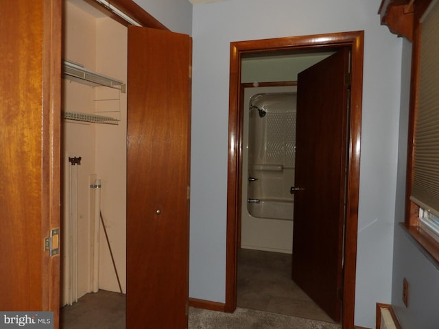 hallway featuring dark colored carpet