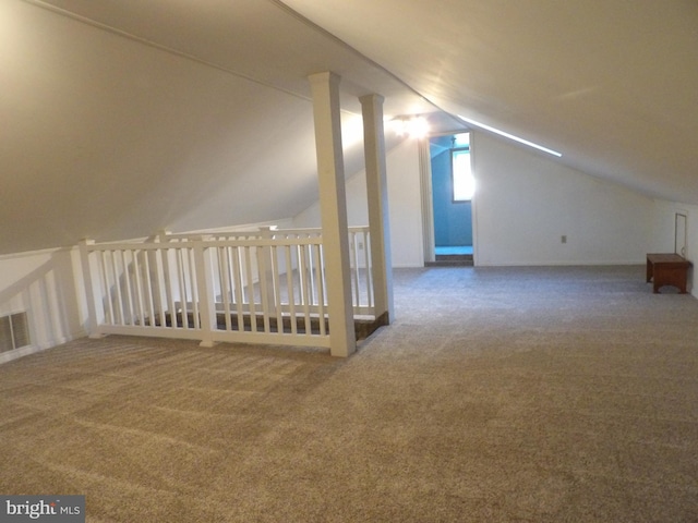 additional living space featuring lofted ceiling and carpet flooring