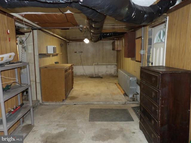 basement with wood walls and radiator heating unit