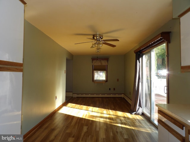 spare room featuring dark wood-type flooring, ceiling fan, and a baseboard radiator