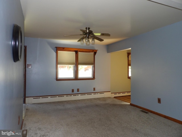 unfurnished room with baseboard heating, light colored carpet, and ceiling fan