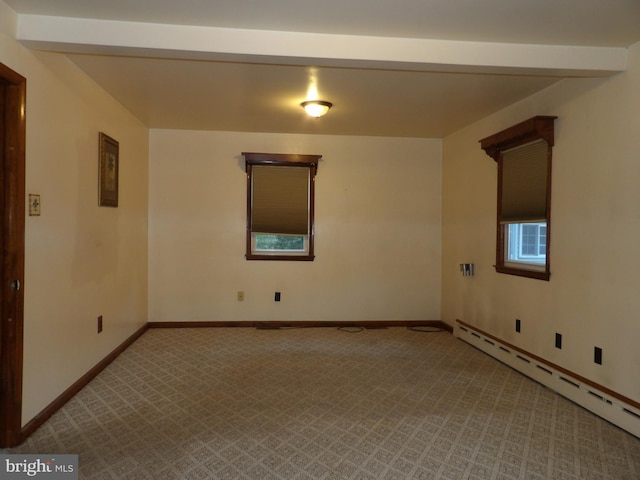 carpeted spare room featuring a baseboard heating unit