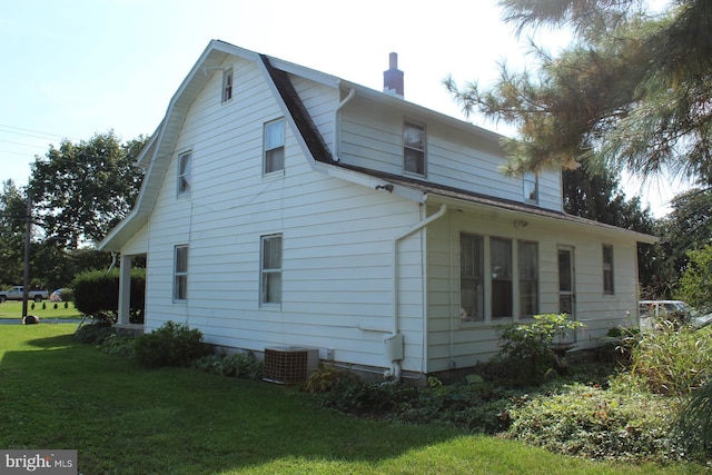 view of side of property with a yard and central AC unit