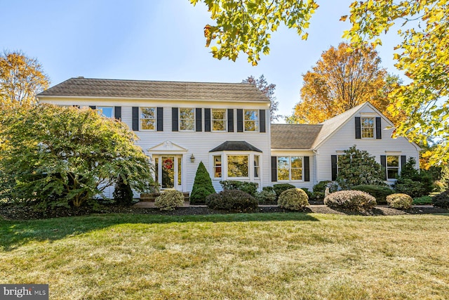 colonial inspired home featuring a front yard