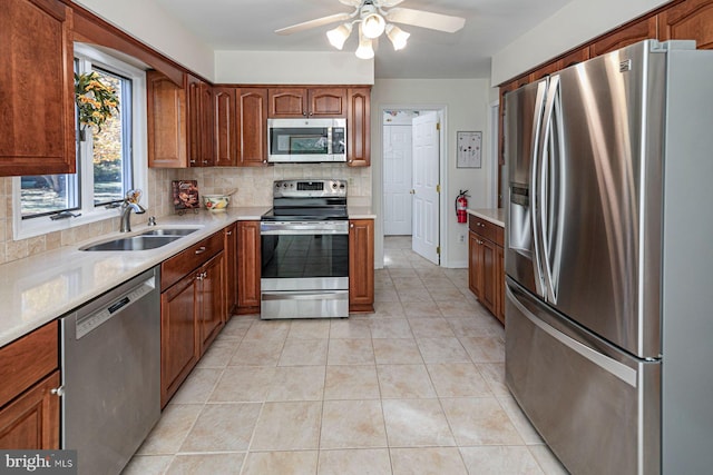 kitchen with decorative backsplash, sink, light tile patterned floors, appliances with stainless steel finishes, and ceiling fan