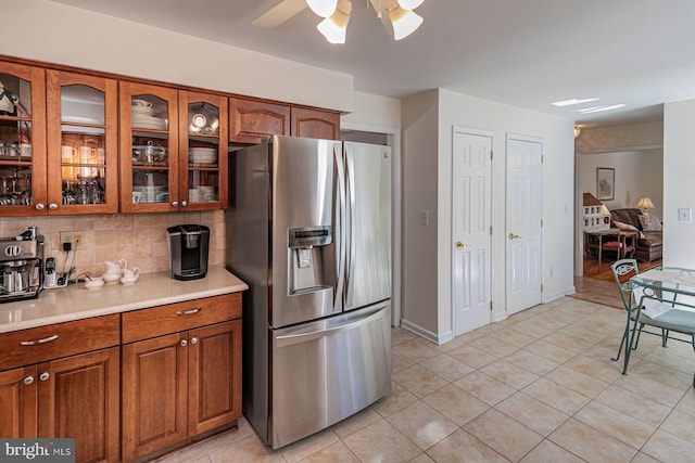 kitchen with stainless steel fridge, decorative backsplash, ceiling fan, and light tile patterned flooring