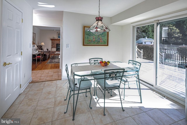 dining room featuring light hardwood / wood-style flooring and a brick fireplace