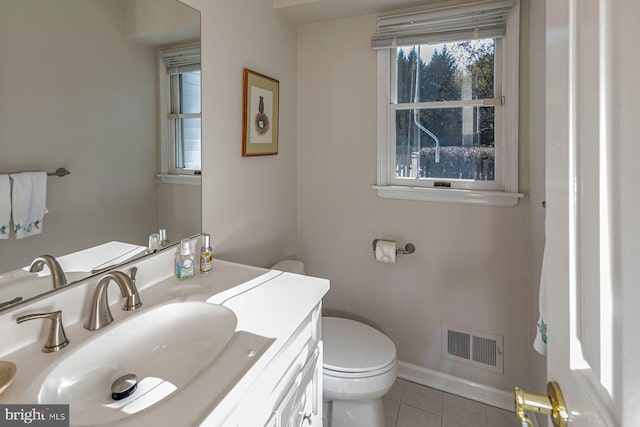 bathroom with toilet, vanity, and tile patterned floors