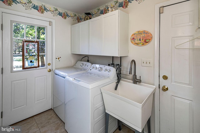 laundry room with sink, light tile patterned flooring, washing machine and dryer, and cabinets