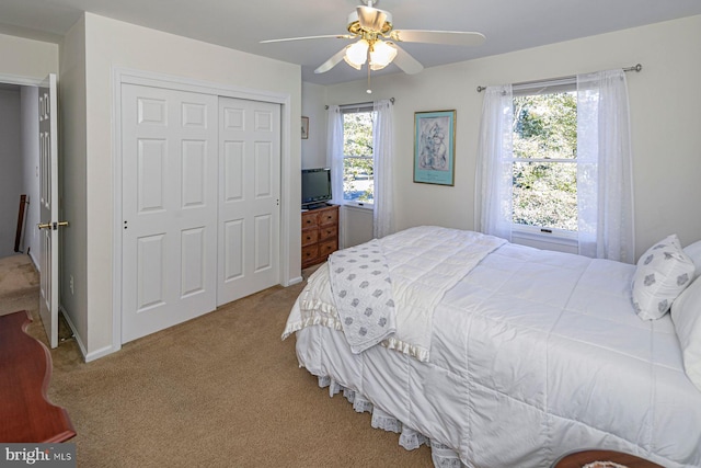 carpeted bedroom featuring a closet and ceiling fan