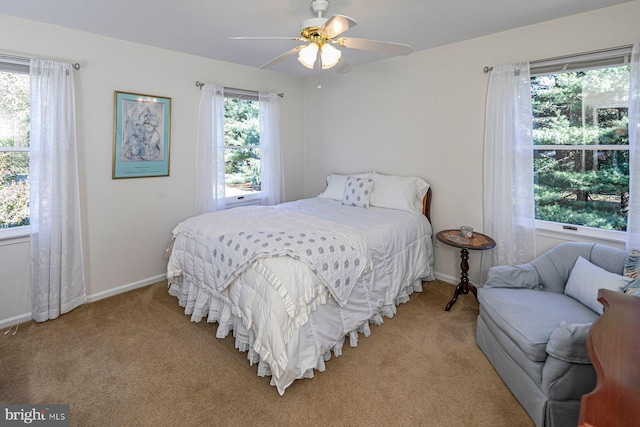 carpeted bedroom with multiple windows and ceiling fan