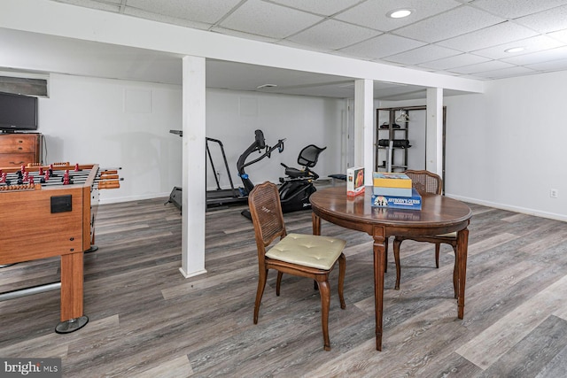 interior space with a paneled ceiling and dark hardwood / wood-style flooring