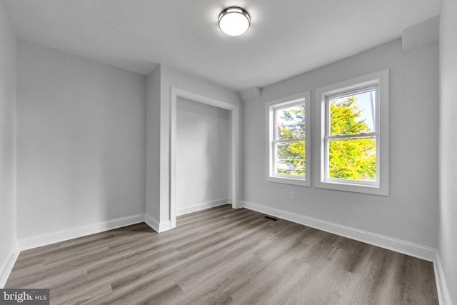 unfurnished bedroom with a closet and light wood-type flooring