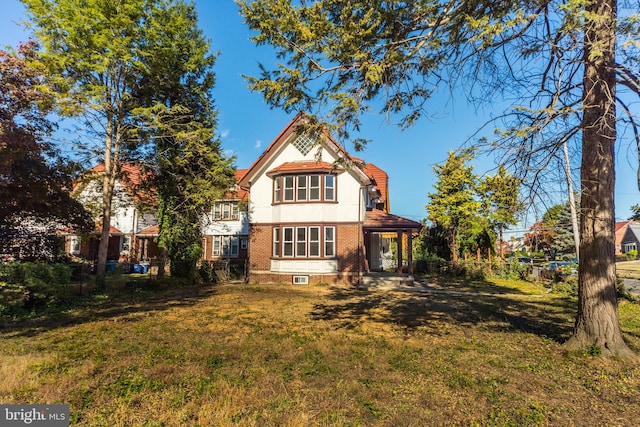 rear view of property with a lawn