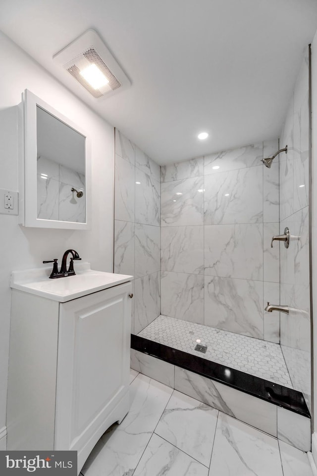 bathroom with vanity and a tile shower