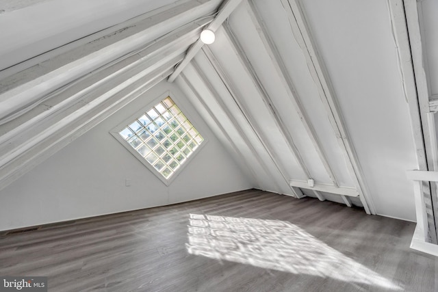 bonus room with hardwood / wood-style flooring and vaulted ceiling