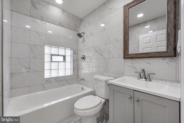 full bathroom with tile walls, vanity, tiled shower / bath combo, and toilet