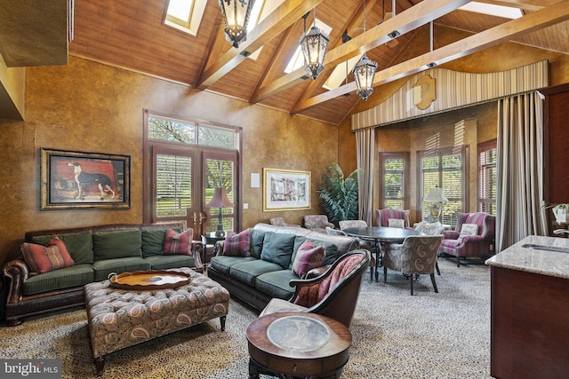 carpeted living area featuring wooden ceiling, beam ceiling, high vaulted ceiling, a wealth of natural light, and a skylight
