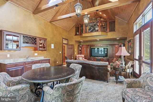 living room with high vaulted ceiling, beamed ceiling, plenty of natural light, and wood ceiling