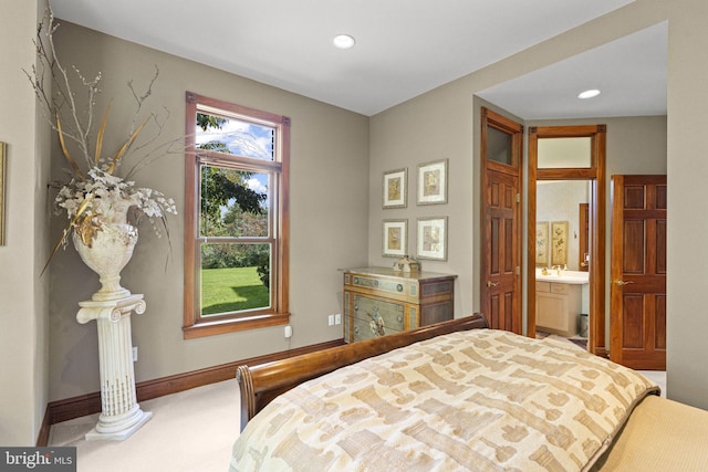 bedroom featuring connected bathroom and carpet