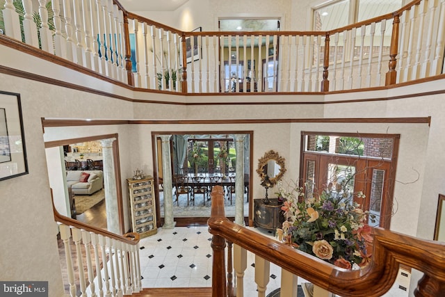 tiled foyer featuring stairway and a high ceiling