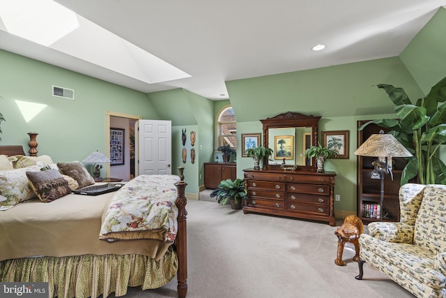 bedroom featuring baseboards, visible vents, vaulted ceiling with skylight, and carpet flooring