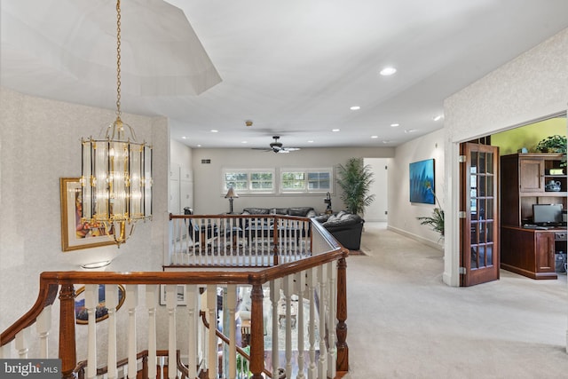 hall with a notable chandelier and carpet