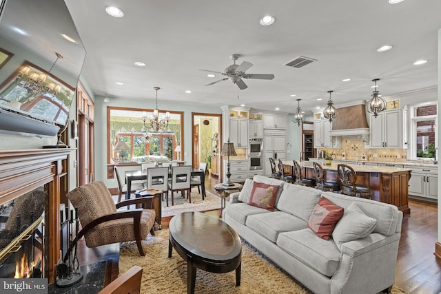 living room with ceiling fan, crown molding, a fireplace, and hardwood / wood-style floors