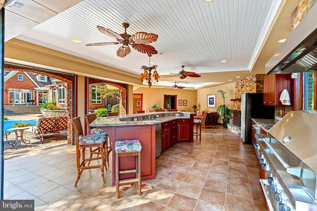 kitchen with a kitchen island, exhaust hood, ornamental molding, a kitchen bar, and appliances with stainless steel finishes