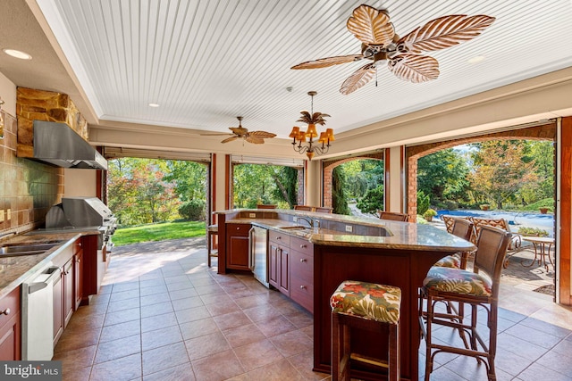 view of patio with area for grilling, outdoor wet bar, ceiling fan, and a sink
