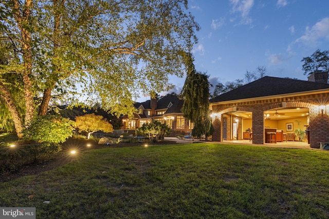 yard at dusk featuring a patio area