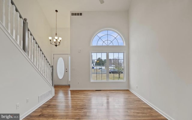 foyer entrance featuring a high ceiling, a chandelier, and hardwood / wood-style floors